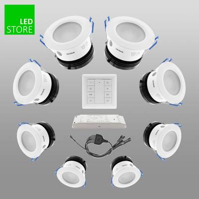 Conjunto de 8 luces LED empotradas blancas, panel de control, fuente de alimentación y cable sobre fondo gris. Perfecto para soluciones de iluminación energéticamente eficientes.