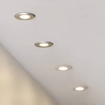 Techo con cuatro luces LED empotradas iluminadas, espaciadas uniformemente para una distribución óptima de la luz en interiores modernos.