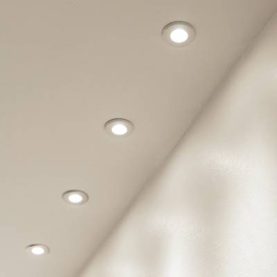 Plafón con cinco luces LED empotradas en fila, que emiten una luz suave sobre una superficie beige. Ideal para una iluminación moderna y de bajo consumo.