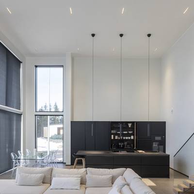Iluminación de cocina moderna con lámparas colgantes, luz natural procedente de grandes ventanales, LED de ambiente y de acento.