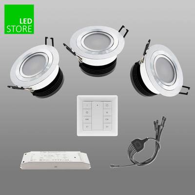 Tres luces LED blancas empotradas con controlador, adaptador y cable sobre fondo gris. Logotipo de LED Store en la esquina superior izquierda. Solución de iluminación energéticamente eficiente.