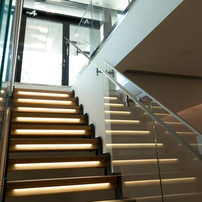 La iluminación de escaleras ilumina las escaleras de cristal; las modernas luces LED realzan el ambiente del interior, con luz natural por encima.