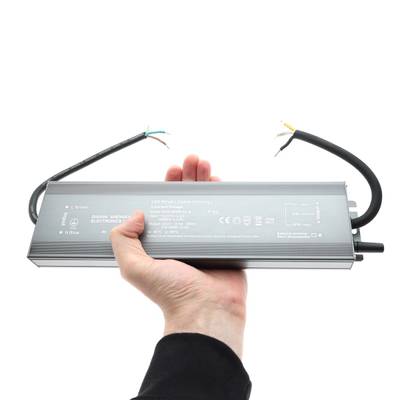 Controlador LED rectangular con cables en la mano, sobre fondo blanco: soluciones de iluminación energéticamente eficientes en nuestra tienda LED.