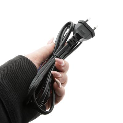 Primer plano de una mano sujetando un cable eléctrico negro trenzado con un enchufe de dos clavijas, aislado con un fondo blanco para soluciones de iluminación LED.