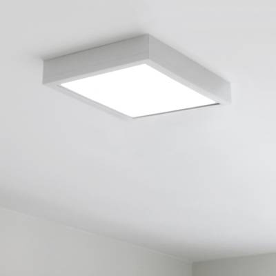 Una lámpara de techo cuadrada con luz blanca brillante en una habitación minimalista pintada de blanco. La moderna iluminación LED acentúa cualquier espacio.