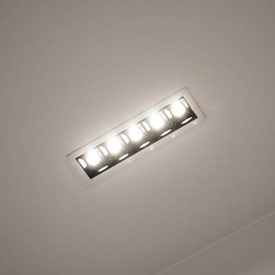 Moderna lámpara LED rectangular de techo con cinco lámparas incandescentes en un techo blanco para una iluminación del hogar eficiente energéticamente y con estilo.