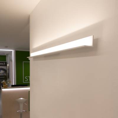 Aplique moderno en una habitación minimalista con paredes blancas, acentuado por un letrero verde - iluminación LED con estilo para interiores elegantes.