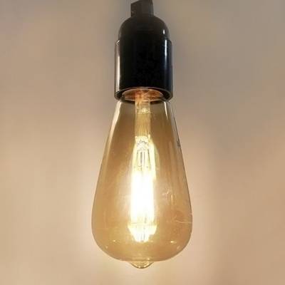 Lámpara LED vintage con base negra, colgada sobre un fondo liso - perfecta para soluciones de iluminación retro y energéticamente eficientes.