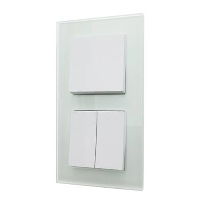 Un panel de interruptores de luz LED blanco contemporáneo con tres interruptores montados en un elegante panel de cristal.