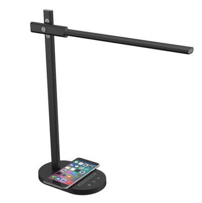Moderna lámpara de mesa LED negra con cargador de teléfono inalámbrico integrado, que presenta un smartphone conectado a una colorida base de carga.