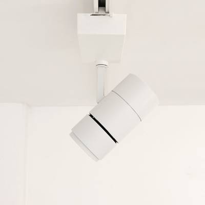 Una moderna lámpara de riel blanca ilumina un techo blanco y realza el interior de su hogar. Iluminación LED de bajo consumo para diseños elegantes y contemporáneos.