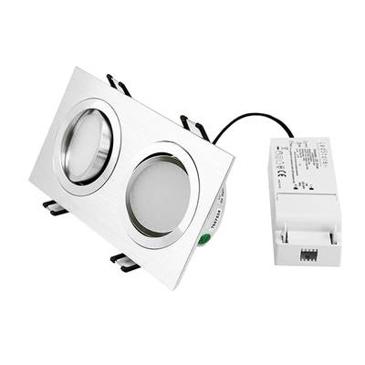 Dos luces LED redondas en un elegante marco plateado y convertidor de corriente blanco, diseño elegante con fondo negro para soluciones de iluminación modernas.