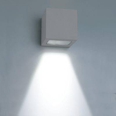 El aplique LED en forma de cubo ilumina un haz brillante y descendente sobre una pared azul suave y acentúa los interiores modernos con una iluminación de bajo consumo.