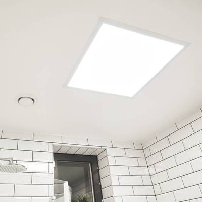Luminaria LED de panel brillante montada en el techo de un cuarto de baño alicatado en blanco con ventana y ventilador, que proporciona una iluminación energéticamente eficiente.