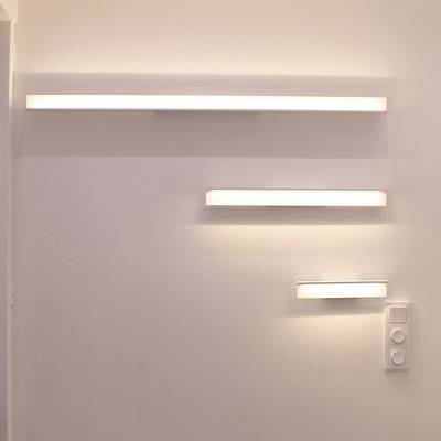 Apliques horizontales minimalistas de diferentes longitudes para una pared lisa con un panel de interruptores de luz debajo. Iluminación LED moderna para tiendas.