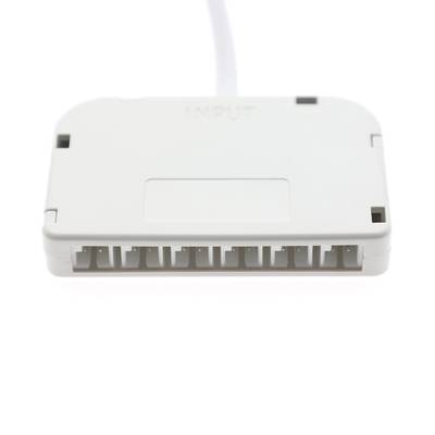 Controlador LED electrónico blanco con puertos de conexión marcados "INPUT" en la parte superior. Se muestra el cable conectado para facilitar la instalación y el uso.