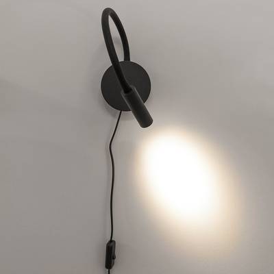 Moderno aplique negro con cuello ajustable y base redonda; emite una suave luz blanca sobre una pared lisa. Ideal para iluminar el hogar con estilo y funcionalidad.