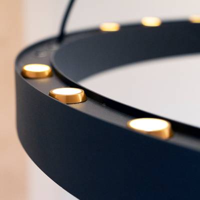 Primer plano de un anillo de luz LED circular negro con luces doradas espaciadas uniformemente, perfecto para fotografía e iluminación de vídeo.