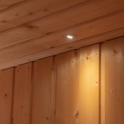 Una luminaria LED montada en el techo ilumina los paneles de madera de la pared inferior.
