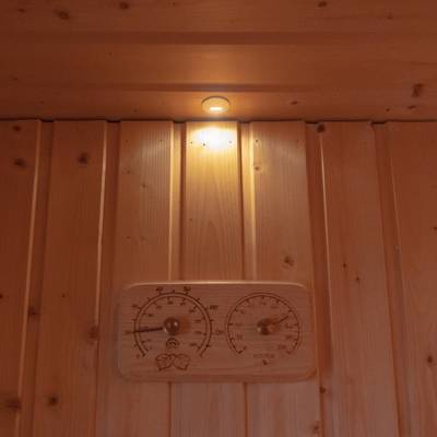 Pantalla de pared con paneles de madera y una pequeña luz iluminada por LED y baldosa de madera con termómetro e higrómetro incorporados para crear un ambiente moderno en el hogar.