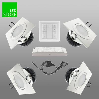 Cuatro conjuntos cuadrados de downlights LED, mando a distancia, fuente de alimentación sobre fondo gris, rótulo verde "LED STORE" para soluciones de iluminación de primera calidad.