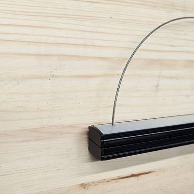Primer plano de un marco negro con estructura de alambre en acabado de madera clara, ideal para una moderna pantalla de iluminación LED en el diseño y la decoración de interiores de viviendas.