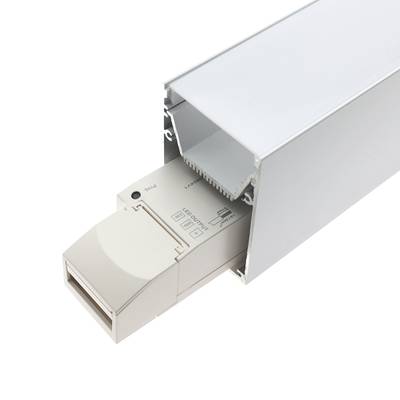 Carril electrificado blanco con controlador LED enchufable parcialmente empotrado, de forma rectangular, con texto y símbolos en su superficie para soluciones de iluminación.