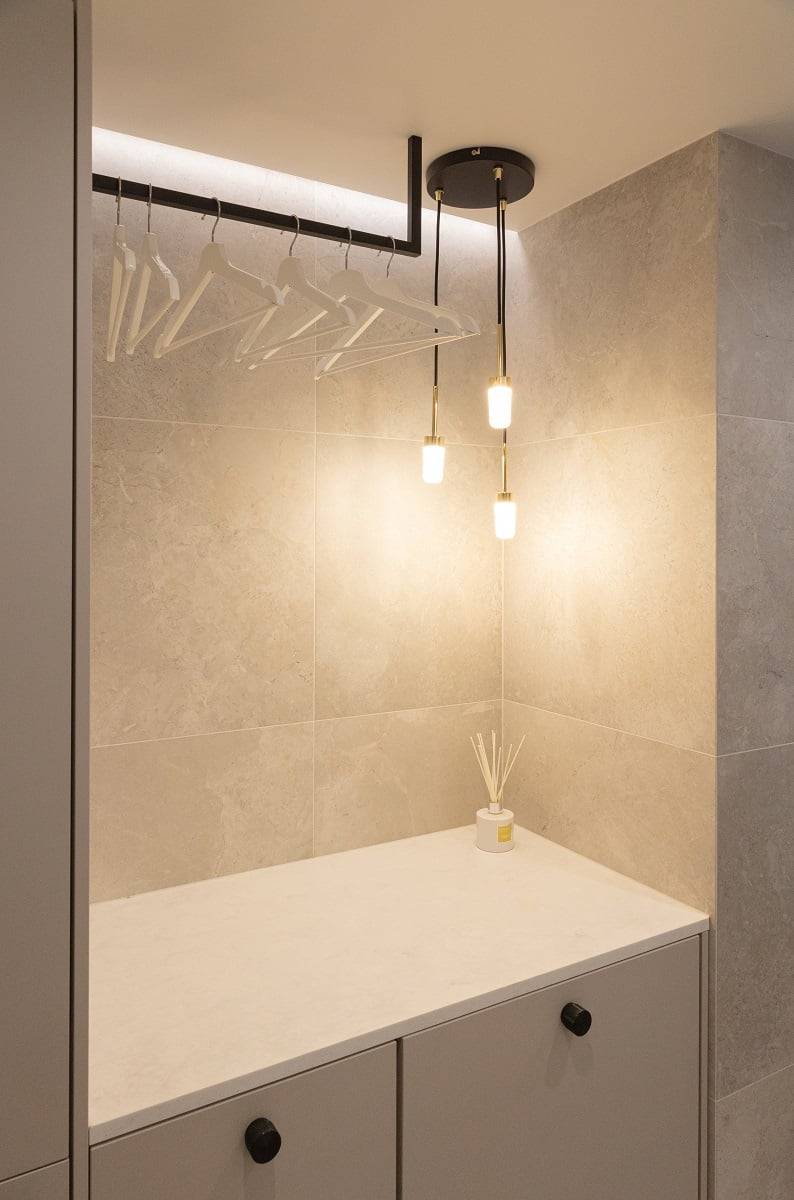 Una elegante lámpara colgante y una tira de LED iluminada en la pared proporcionan una hermosa luz en el perchero. © LedStore