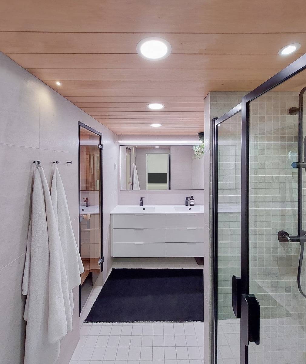 Iluminación versátil para el cuarto de baño. Plafones más grandes para iluminación general, tira de luz LED montada sobre cables encima del espejo, foco en el hueco de la ducha. ©LedStore