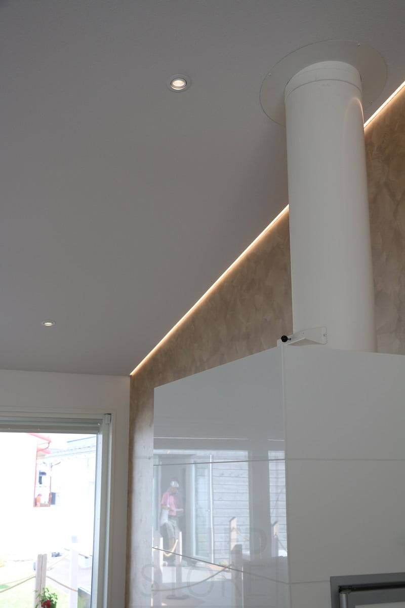 Feria de la Vivienda 2018: perfil led en un techo inclinado y ascendente, en la interfaz pared/techo, detrás de la chimenea. Ledstore.fi