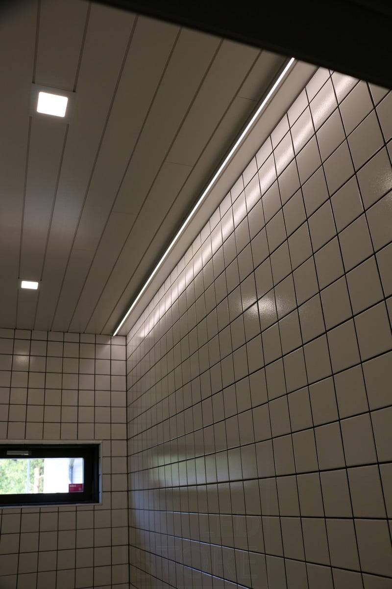 Feria de la Vivienda 2019: Tira de leds en el techo junto a la pared, luz reflejada en el azulejo brillante. Ledstore.fi