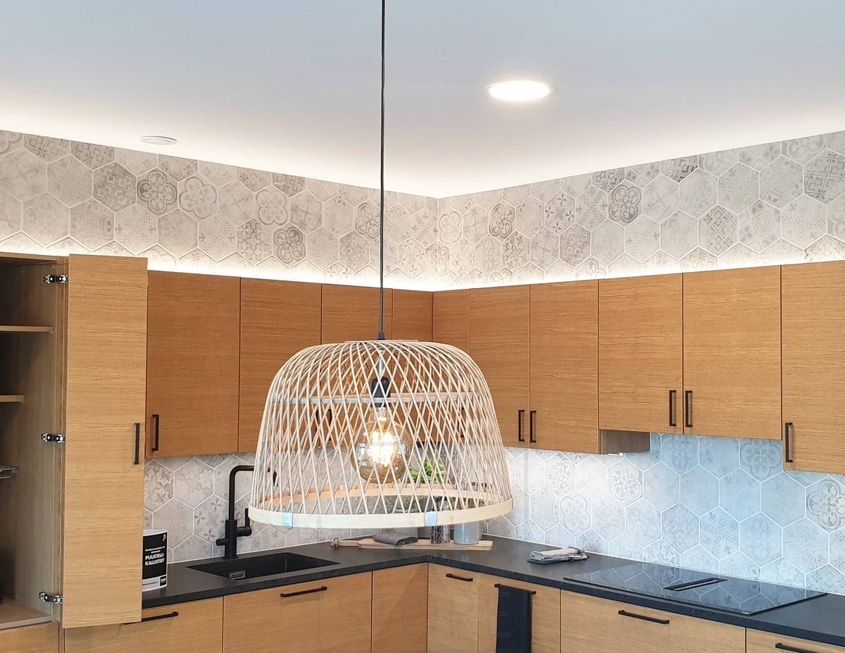Feria de la Vivienda 2020: luces indirectas en el armario de la cocina sobre la cocina de roble. Plafones en el techo y una luz colgante sobre la mesa del comedor. Ledstore.fi