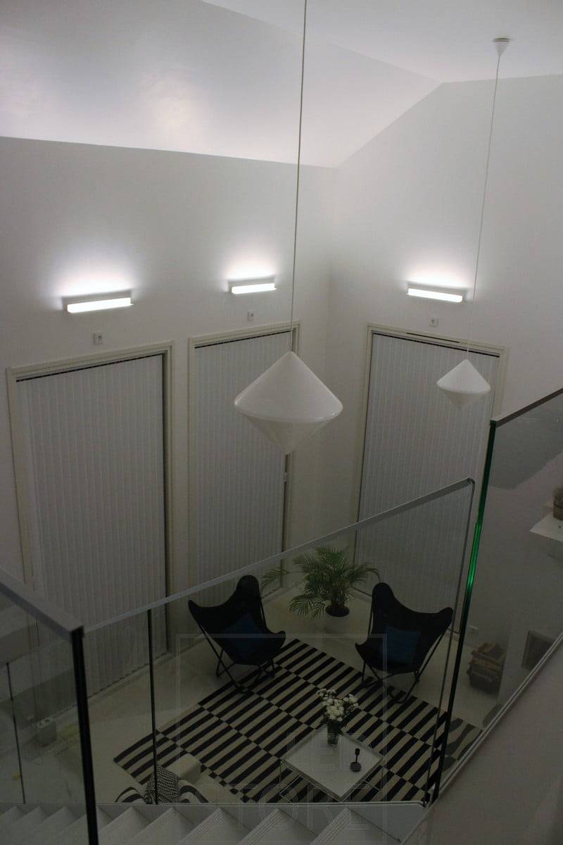 Un salón con iluminación indirecta atmosférica creada con apliques Led BLADE. La luminaria está montada para iluminar desde abajo hacia arriba, por lo que la iluminación indirecta también enfatiza la altura del espacio. Ledstore.fi
