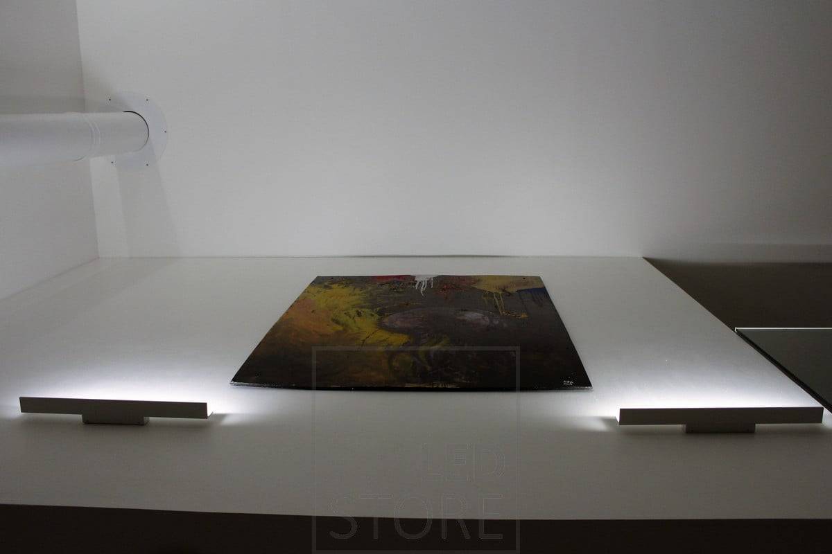 Aplique de pared Blade que ilumina de abajo arriba y resalta las obras de arte con luz indirecta. Ledstore.fi