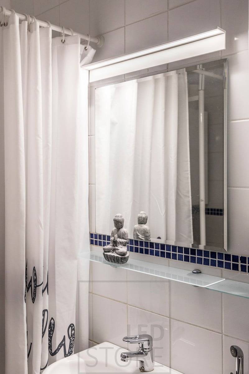 Lámpara de pared Blade sobre el espejo del cuarto de baño. La luminaria ilumina bien tanto la cara como el espejo. Ledstore.fi