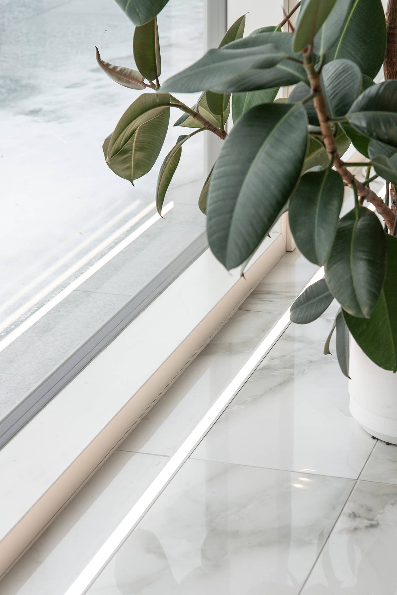 Frente a las ventanas, el suelo se acentúa con una cinta de leds en el perfil empotrado. La cinta led en el suelo también resalta la hermosa baldosa de mármol. Ledstore.fi