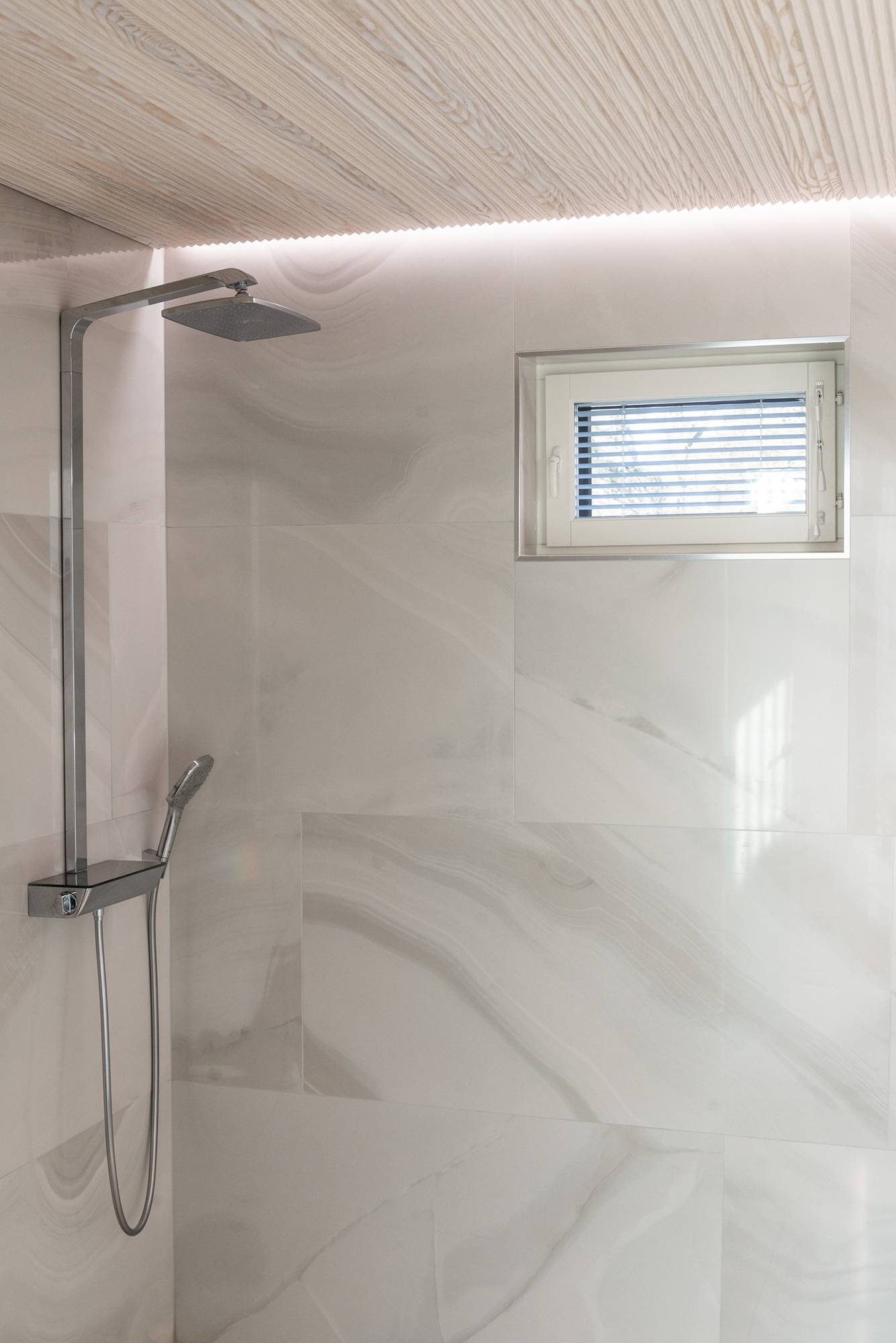 Tira de leds entre el techo y la pared que ilumina indirectamente la ducha, creando una atmósfera de spa. Ledstore.fi