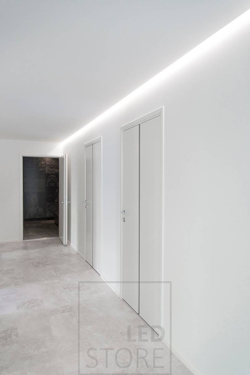 Bonita iluminación de un pasillo con luz indirecta, tira de LED instalada en la ranura entre el techo y la pared. Ledstore.fi