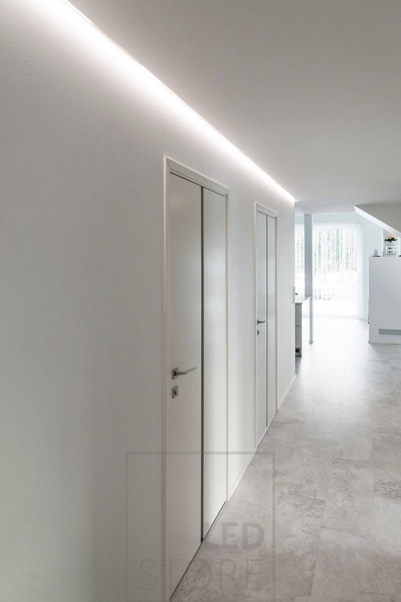 Un pasillo bellamente iluminado con luz indirecta. Tira de leds en perfil de aluminio montada en la ranura entre el techo y la pared. Ledstore.fi