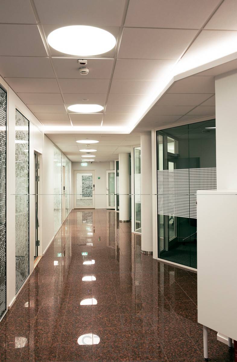 Tira de leds montada en el downlight de un pasillo creando luz indirecta atmosférica a través del techo. Iluminación general realizada con luminarias Plafondi empotradas.