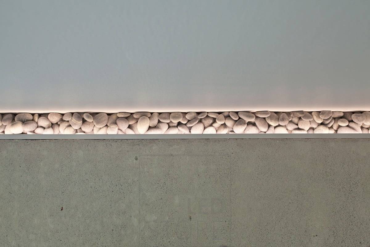 Un bonito detalle en el suelo resaltado por una tira de leds. Cuando se estaba vertiendo el suelo, se dejó un pequeño hueco junto a la pared para añadir piedras y se instaló iluminación ambiental para resaltar las piedras. También funciona como luz nocturna ambiental. Ledstore.fi