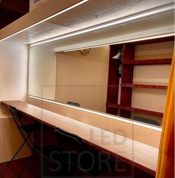 Gimnasio doméstico iluminado con focos y luz indirecta atmosférica. La iluminación indirecta se consigue con una tira de luz LED instalada entre el techo y la pared.