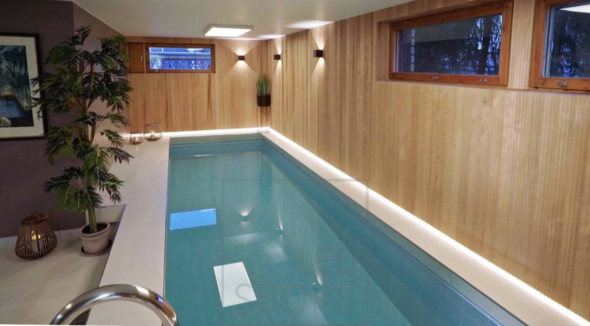 La zona de la piscina está atmosféricamente iluminada por apliques FUNK negros y, tras el hermoso revestimiento, el borde del suelo está iluminado por una tira de LED. Ledstore.fi