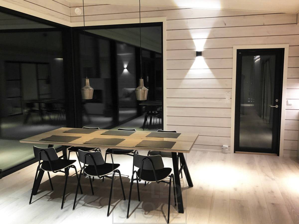 Aplique led negro FUNK que crea una iluminación ambiental indirecta en la pared del comedor. Ledstore.fi