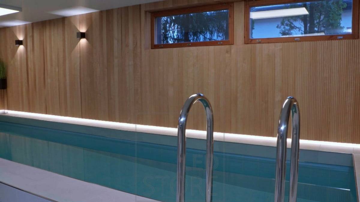 La zona de la piscina está atmosféricamente iluminada con apliques FUNK y, tras el hermoso revestimiento, el borde del suelo está iluminado con luz indirecta procedente de tiras de LED. Ledstore.fi