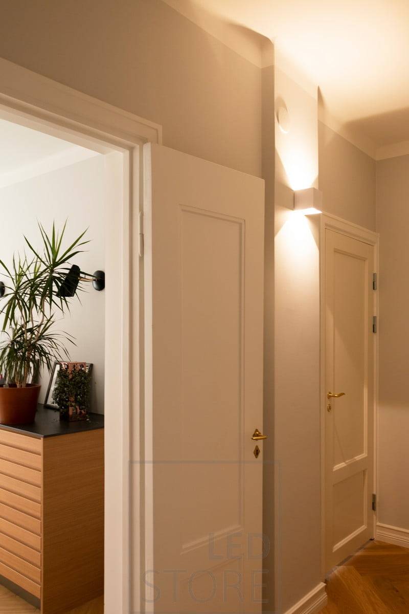 Dentro del pasillo, un aplique FUNK blanco ilumina el pasillo con luz atmosférica. Adecuada tanto para exteriores como para interiores. Ledstore.fi