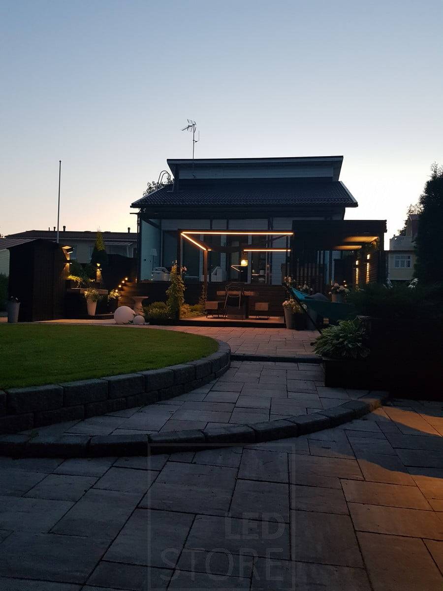 Aplique led FUNK como parte de un sistema de iluminación de patio. Cinta de LED alrededor de la zona de comedor. Ledstore.fi