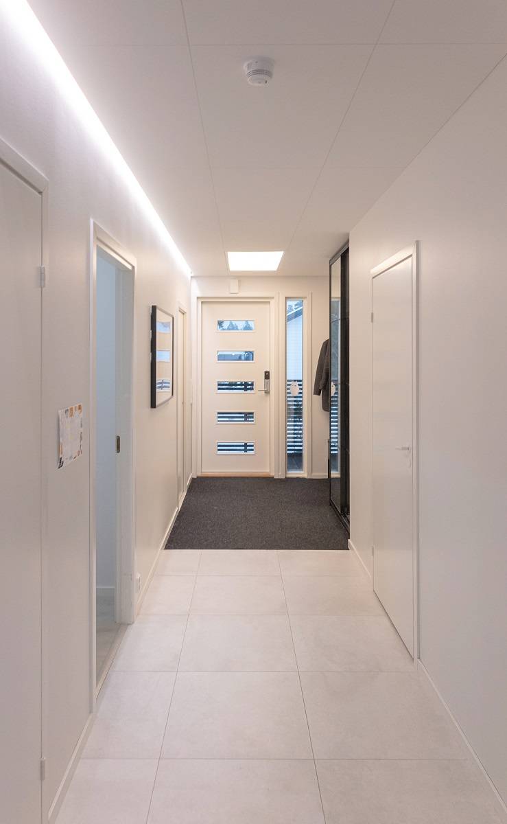 Tira de luz LED en el borde de una ranura abatible en un vestíbulo.
