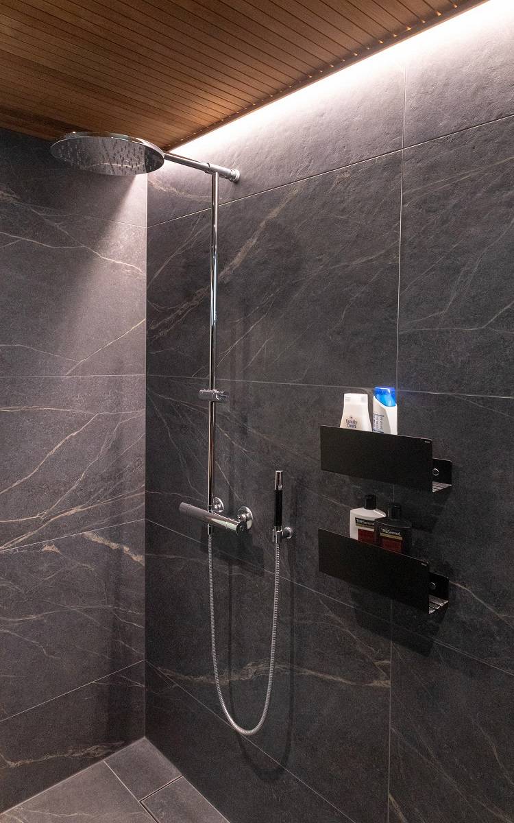 Cuarto de baño con tira de leds en el hueco entre la pared y el techo en un borde.