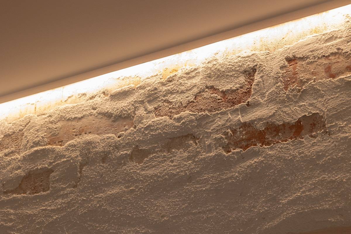 Tira de LED instalada en el borde superior de la pared decorativa para iluminar hacia abajo.
